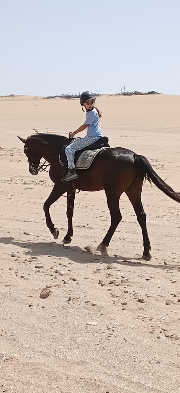 Jeune cavalière sur Assif traversant les dunes